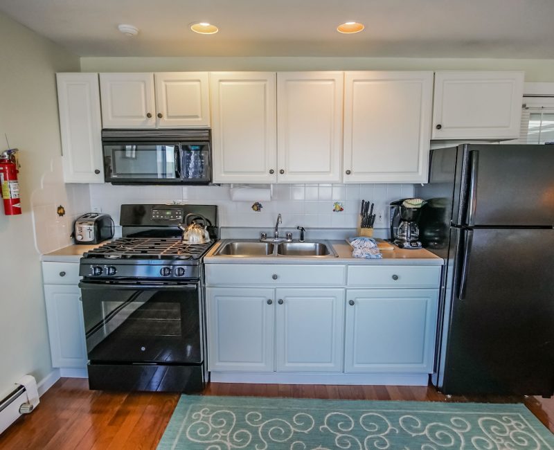 Photo of Kitchen showcasing stove, refrigerator, sink, microwave, cabinets and small appliances